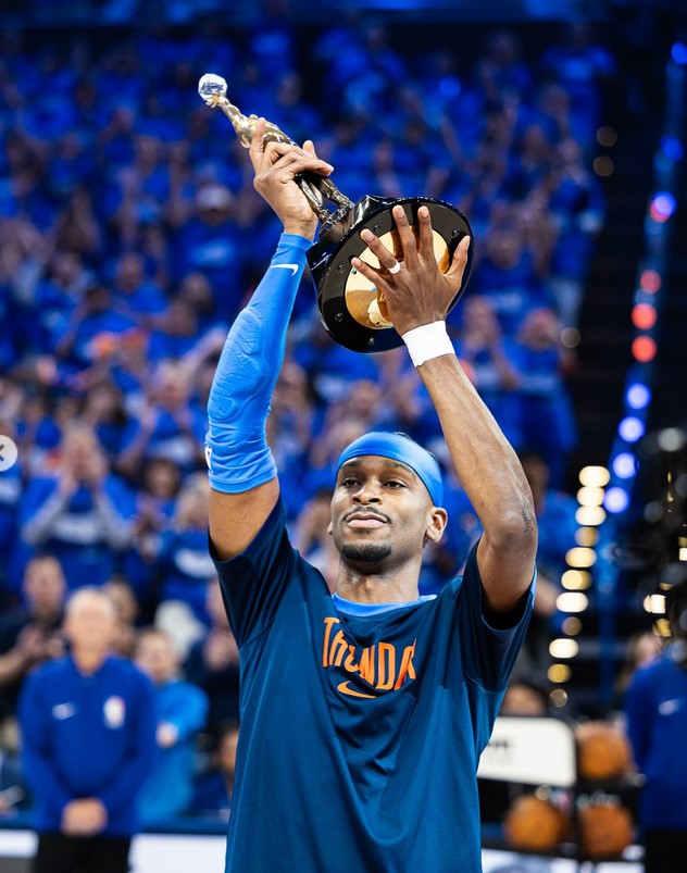 Shai-Gilgeous Alexander hoisting his MVP Trophy